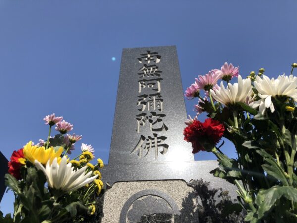 供えられた花と墓石の一部