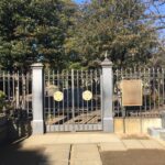 寛永寺にある徳川慶喜公墓所の門と鉄柵。中央に葵の紋と解説板が見える。