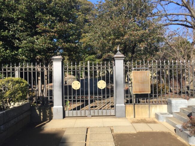 寛永寺にある徳川慶喜公墓所の門と鉄柵。中央に葵の紋と解説板が見える。