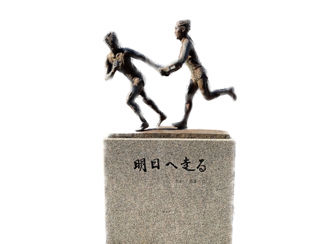 タスキをつなぐ瞬間を表した彫刻（台座に「明日へ走る」）